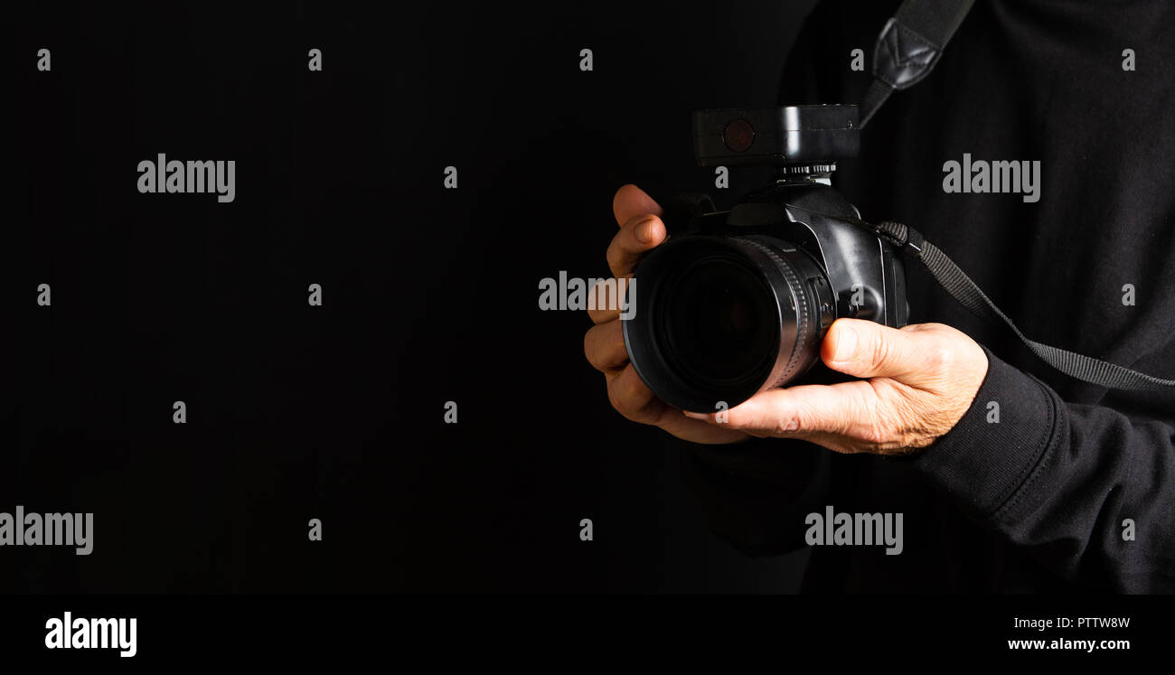Person holding a DSLR camera close up Stock Photo