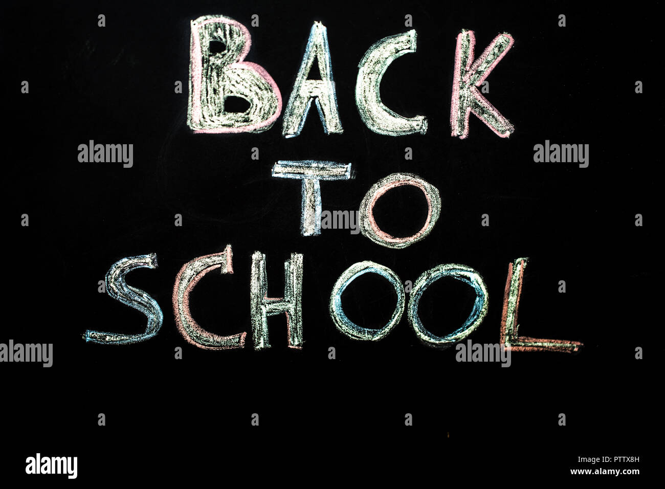 inscription in chalk back to school on black chalkboard education