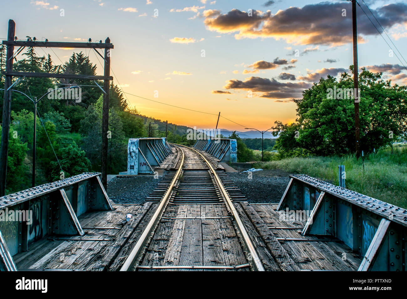 Railroad tracks leading into the sunset in Ashland, Oregon Stock Photo
