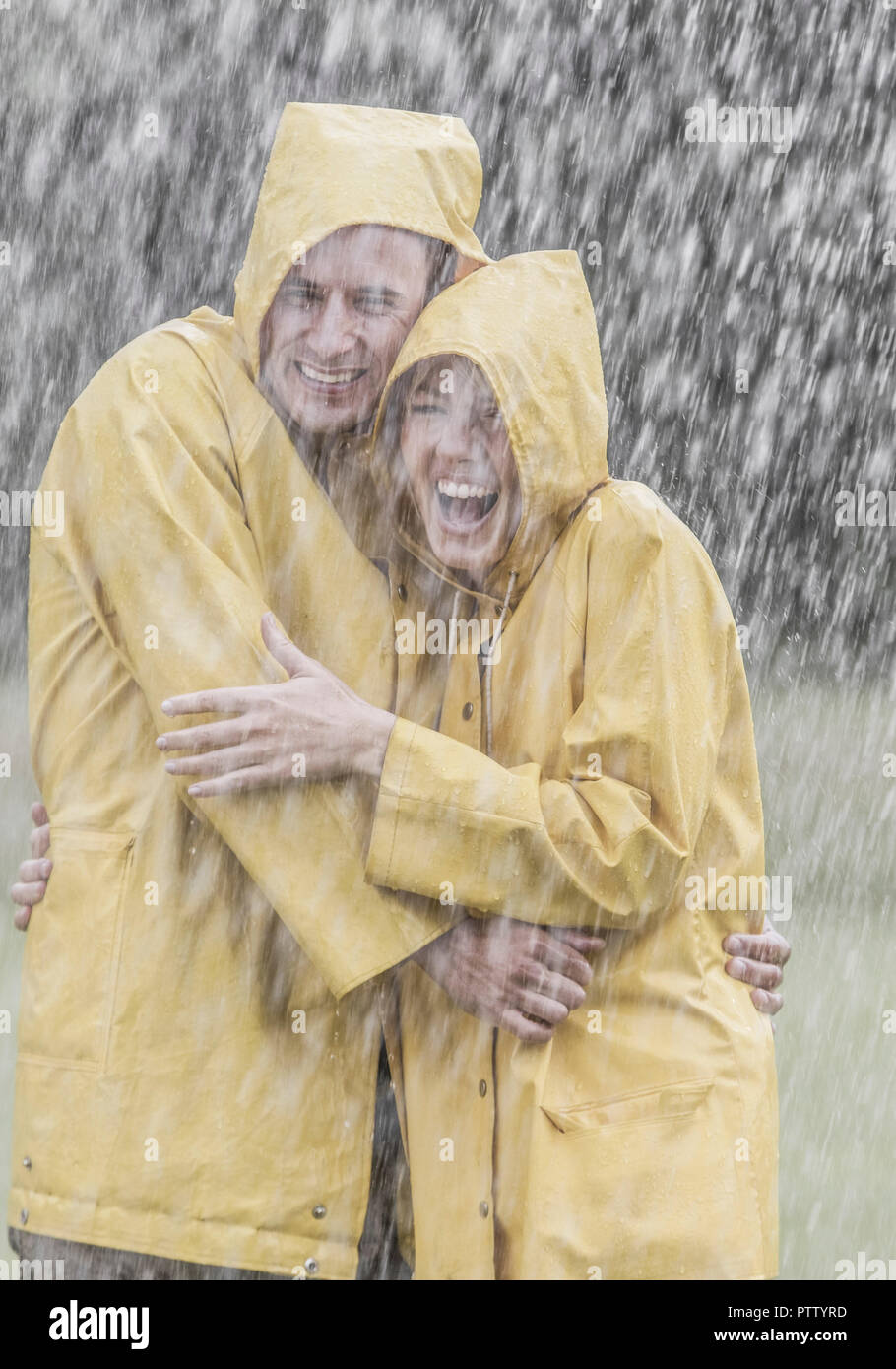 Paar Stehen In Gelben Regenjacken Im Regen Lachen Model Released Stock Photo Alamy
