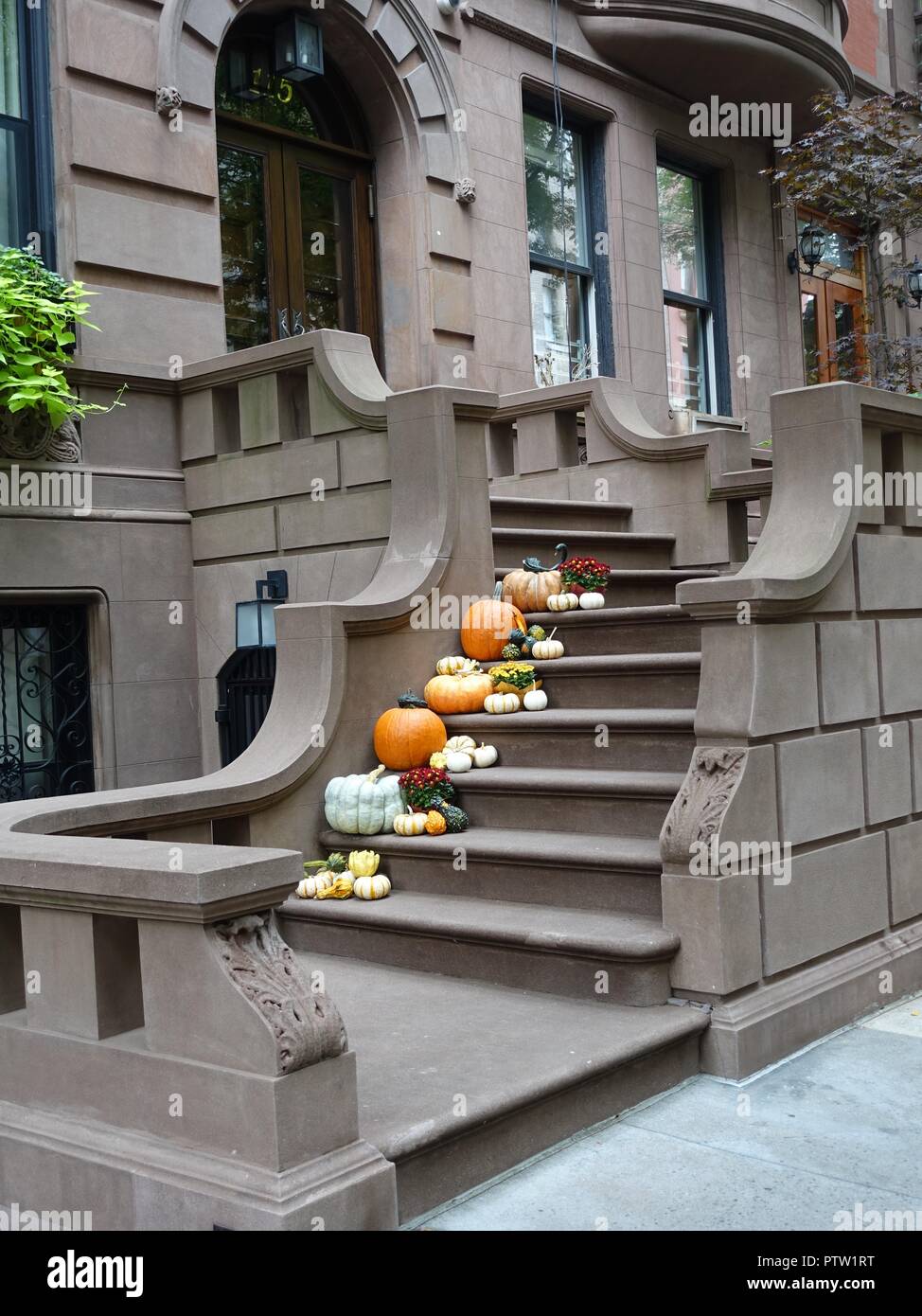 Autumnal display of pumpkins and squash line the steps of un upper westside brownstone building, New York, NY, USA. Stock Photo