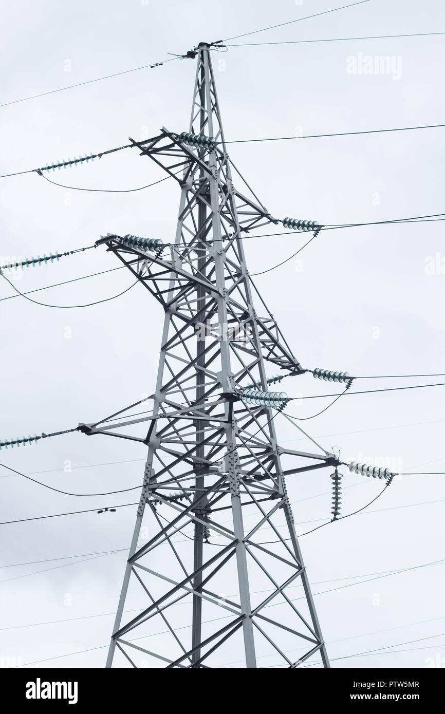 Metal high-voltage support, electric derrick against the sky, close-up Stock Photo