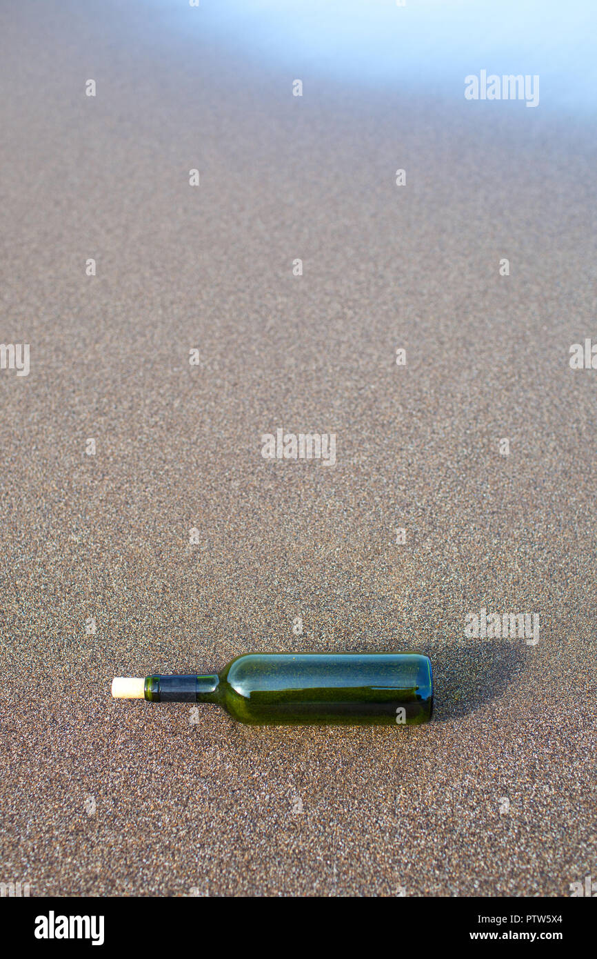glass bottle on the sand of a beach Stock Photo - Alamy