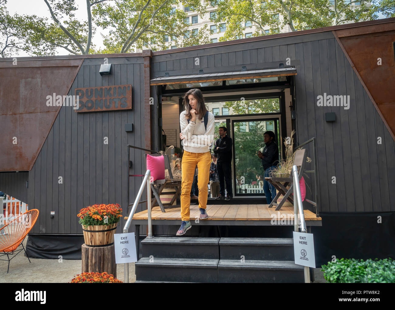 Visitors to Madison Square Park in New York on Friday, October 5, 2018 visit the Dunkin' Donuts Tiny Home, made by New Frontier Tiny Homes. The power for the 275 square-foot home runs on biofuel created from 80 percent spent Dunkin' coffee grounds, mixed with alcohol. Dunkin' Brands recently changed their name dropping the 'donuts' moniker to better reflect that 60 percent of their sales are coffee beverages. (Â© Richard B. Levine) Stock Photo