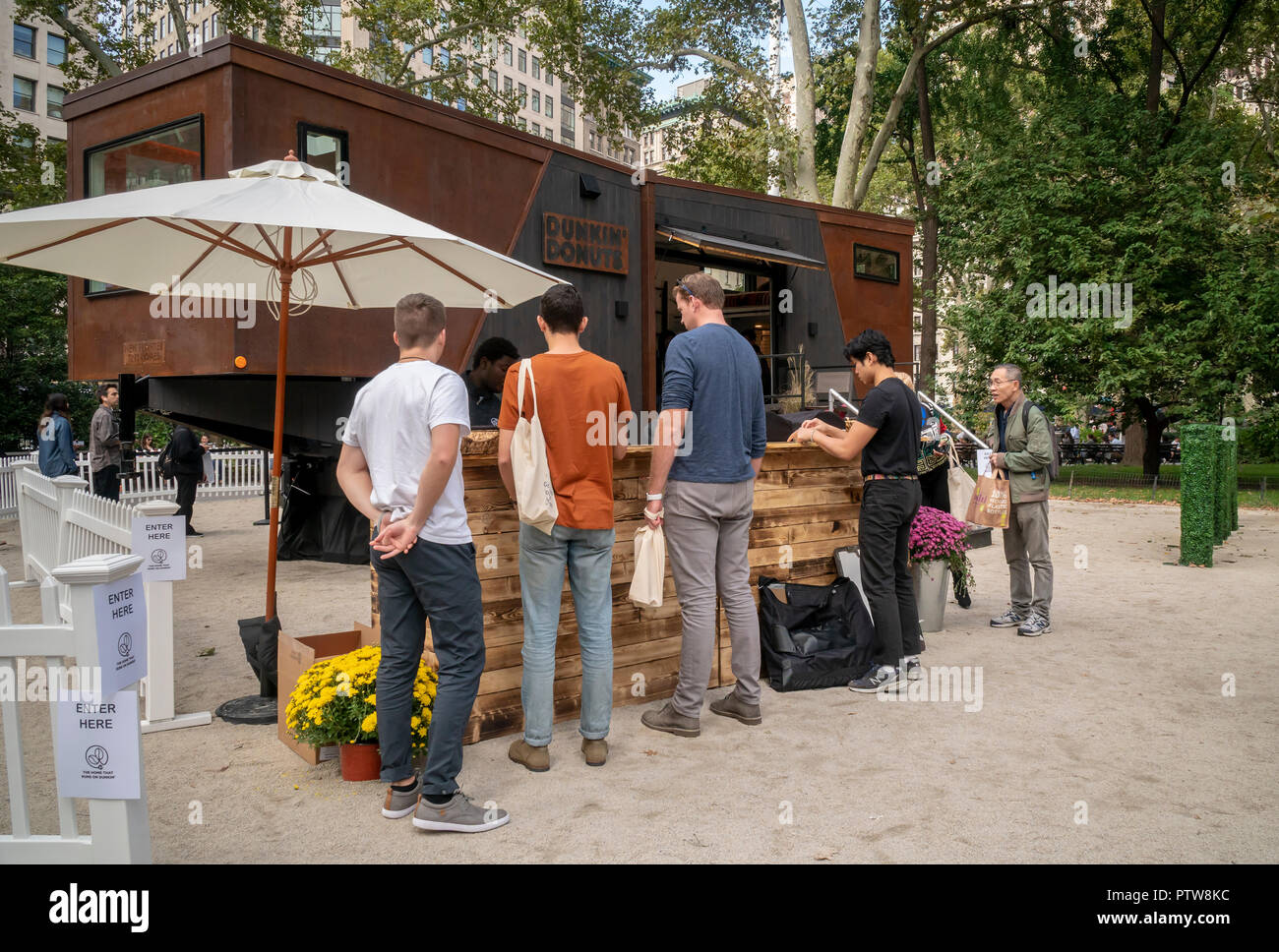 Visitors to Madison Square Park in New York on Friday, October 5, 2018 visit the Dunkin' Donuts Tiny Home, made by New Frontier Tiny Homes. The power for the 275 square-foot home runs on biofuel created from 80 percent spent Dunkin' coffee grounds, mixed with alcohol. Dunkin' Brands recently changed their name dropping the 'donuts' moniker to better reflect that 60 percent of their sales are coffee beverages. (© Richard B. Levine) Stock Photo