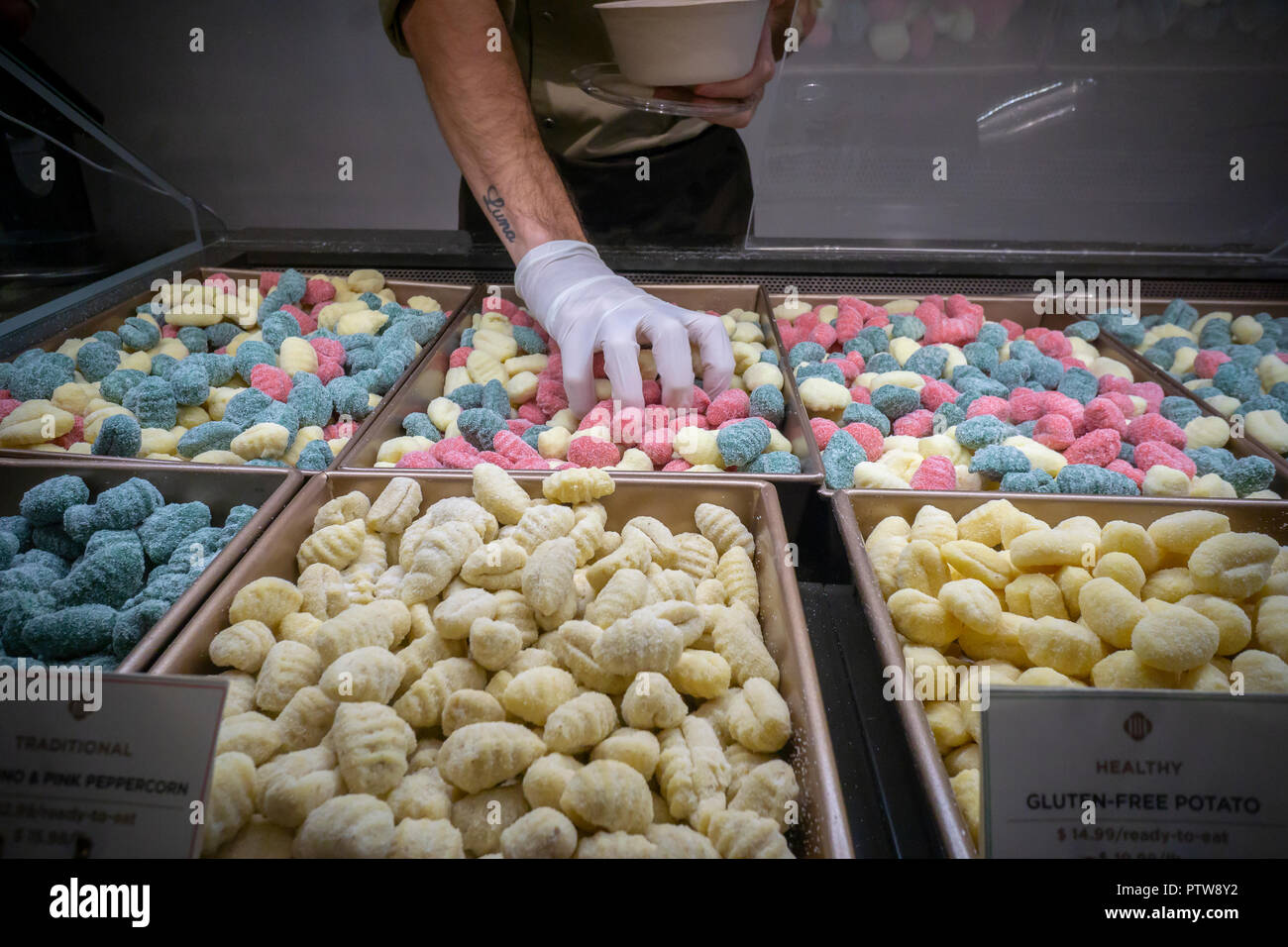 A worker prepares an order of tricolor gnocchi in Patavini, a Padua, Italy based gnocchi maker, at their newly opened store in New York on Wednesday, October 10, 2018. The gnocchis come in a myriad of different flavors and are sold by the pound to prepare at home or cooked as take-out. (© Richard B. Levine) Stock Photo