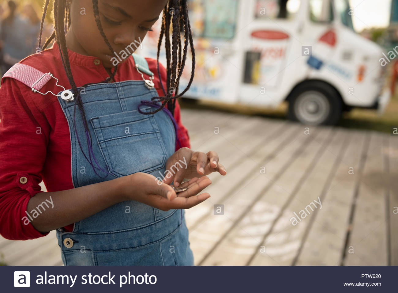 Cute girl counting coins outside ice cream truck Stock Photo