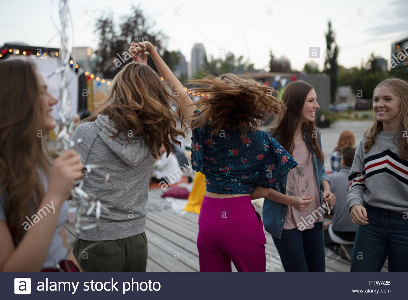 Teenage girls dancing at movie in the park Stock Photo