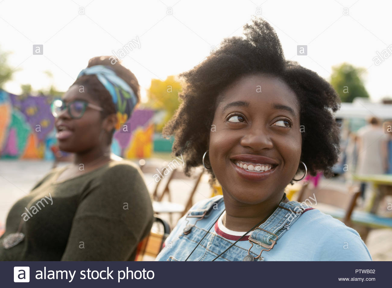 Portrait smiling young woman looking over shoulder Stock Photo