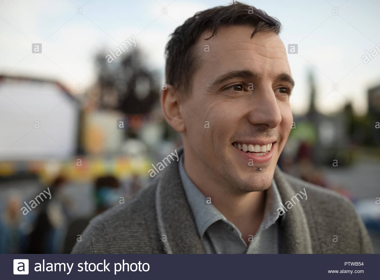 Portrait smiling man with chin piercing looking away Stock Photo