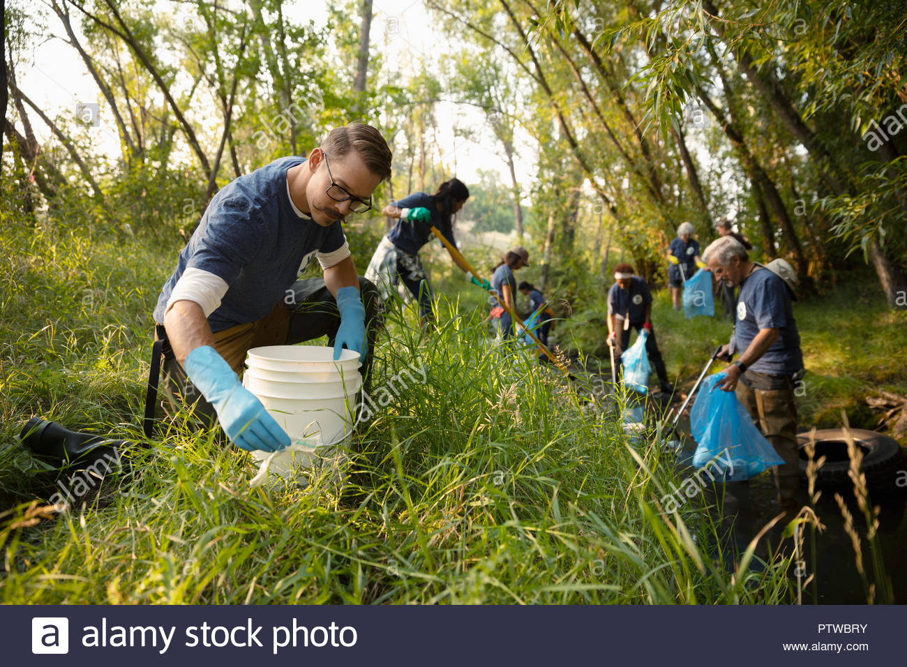 Man volunteering, cleaning up garbage in park Stock Photo Alamy