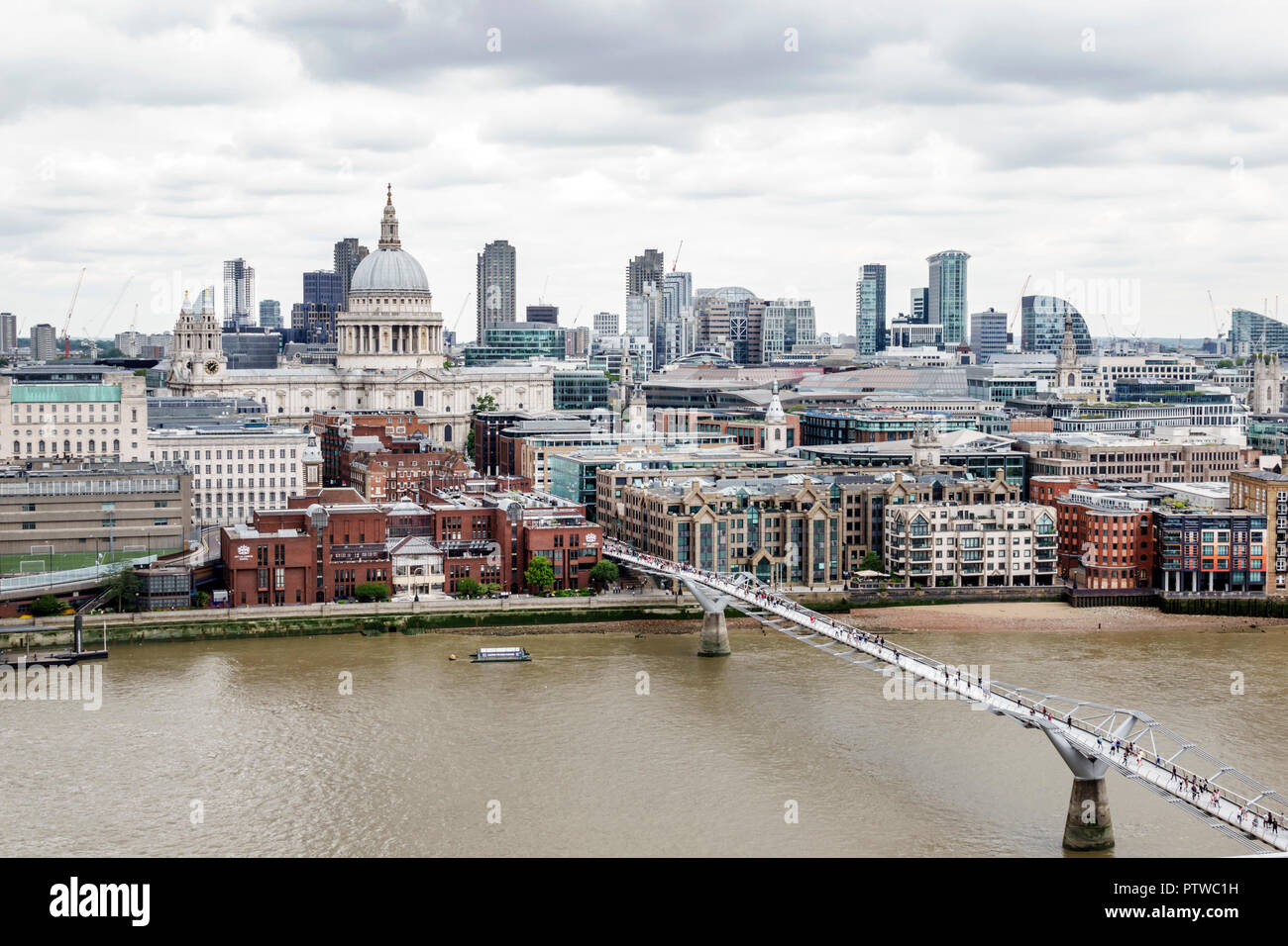 London England,UK,Bankside,River Thames,Tate Modern art museum terrace view,city skyline,gray sky,Millennium Bridge,suspension footbridge,St Paul's Ca Stock Photo