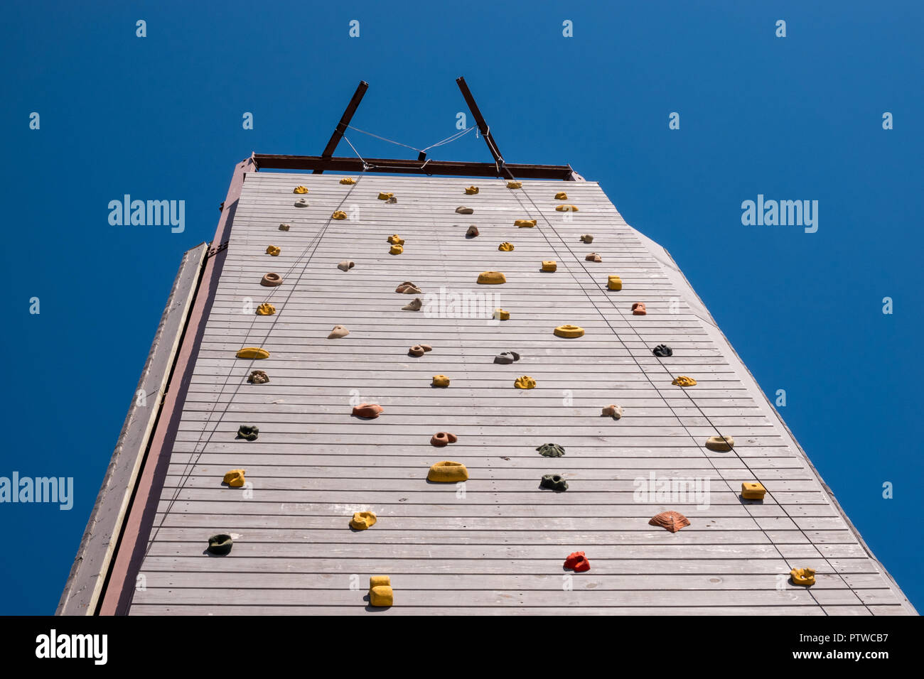 View up to top of a high artificial climbing wall Stock Photo