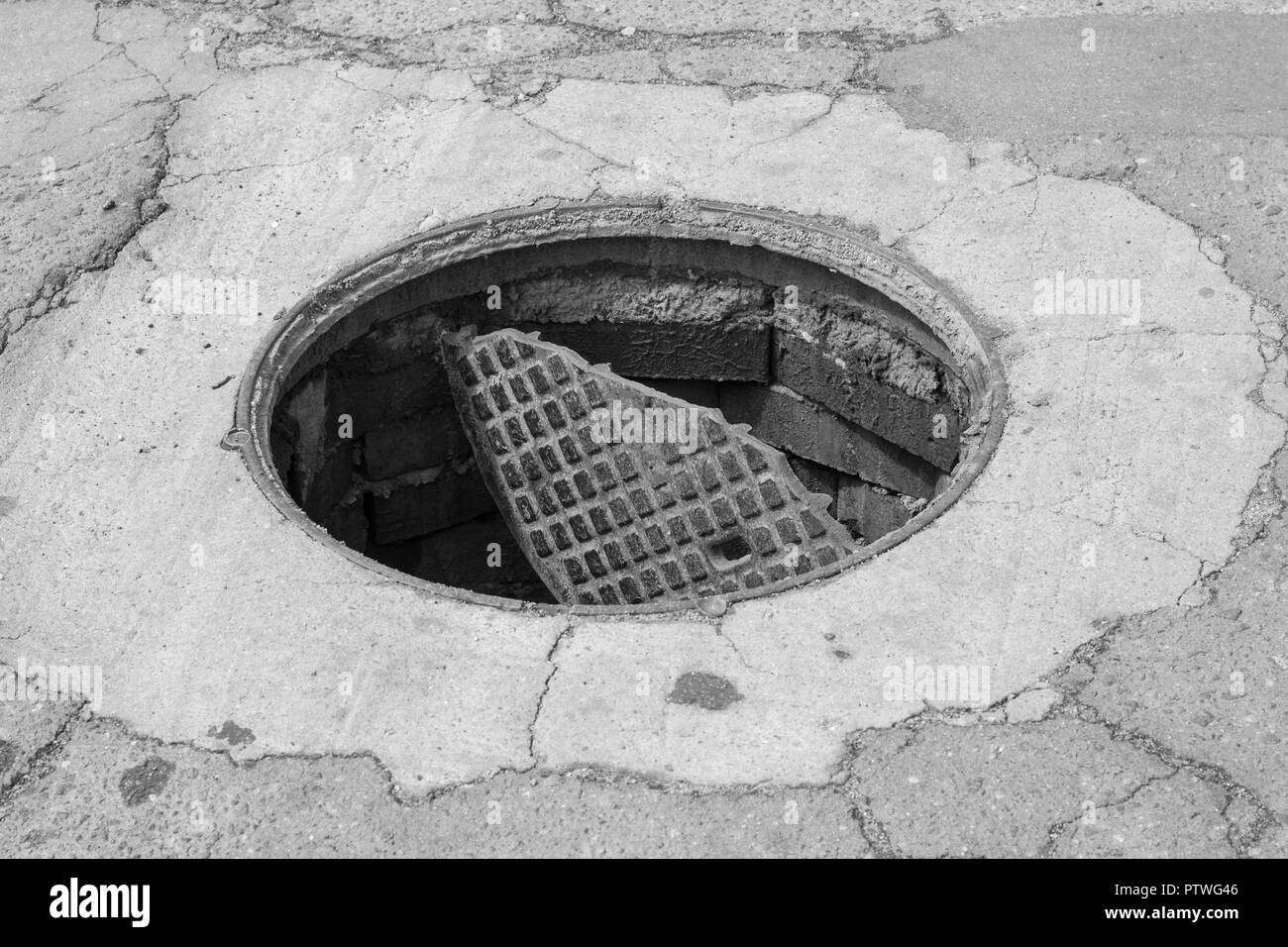 Outdoor sewer hatch, close up, broken and open sewer cover Stock Photo