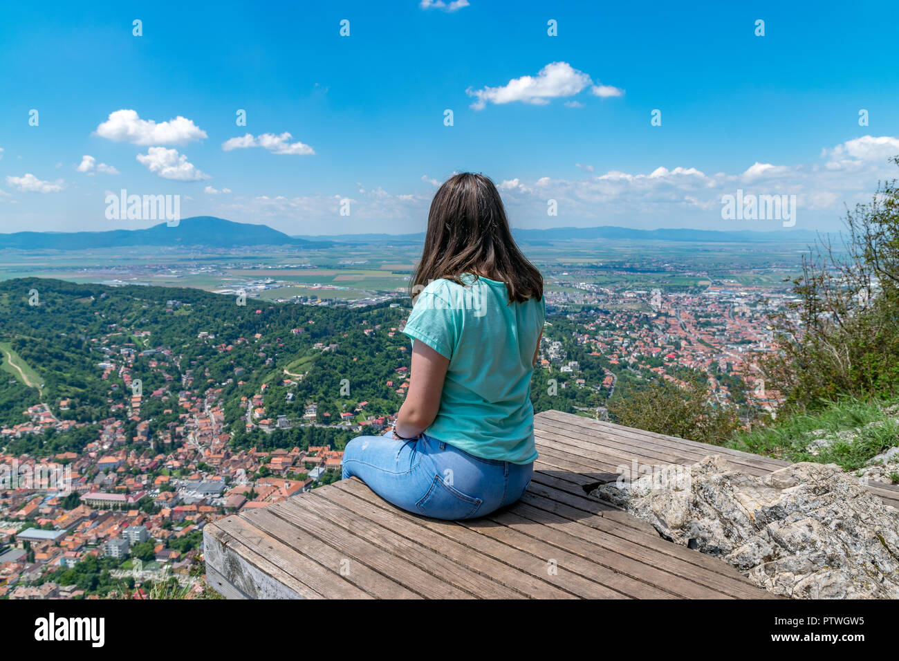 Girl admiring the overview of Brasov city from Tampa mountain in Brasov, Romania. Stock Photo