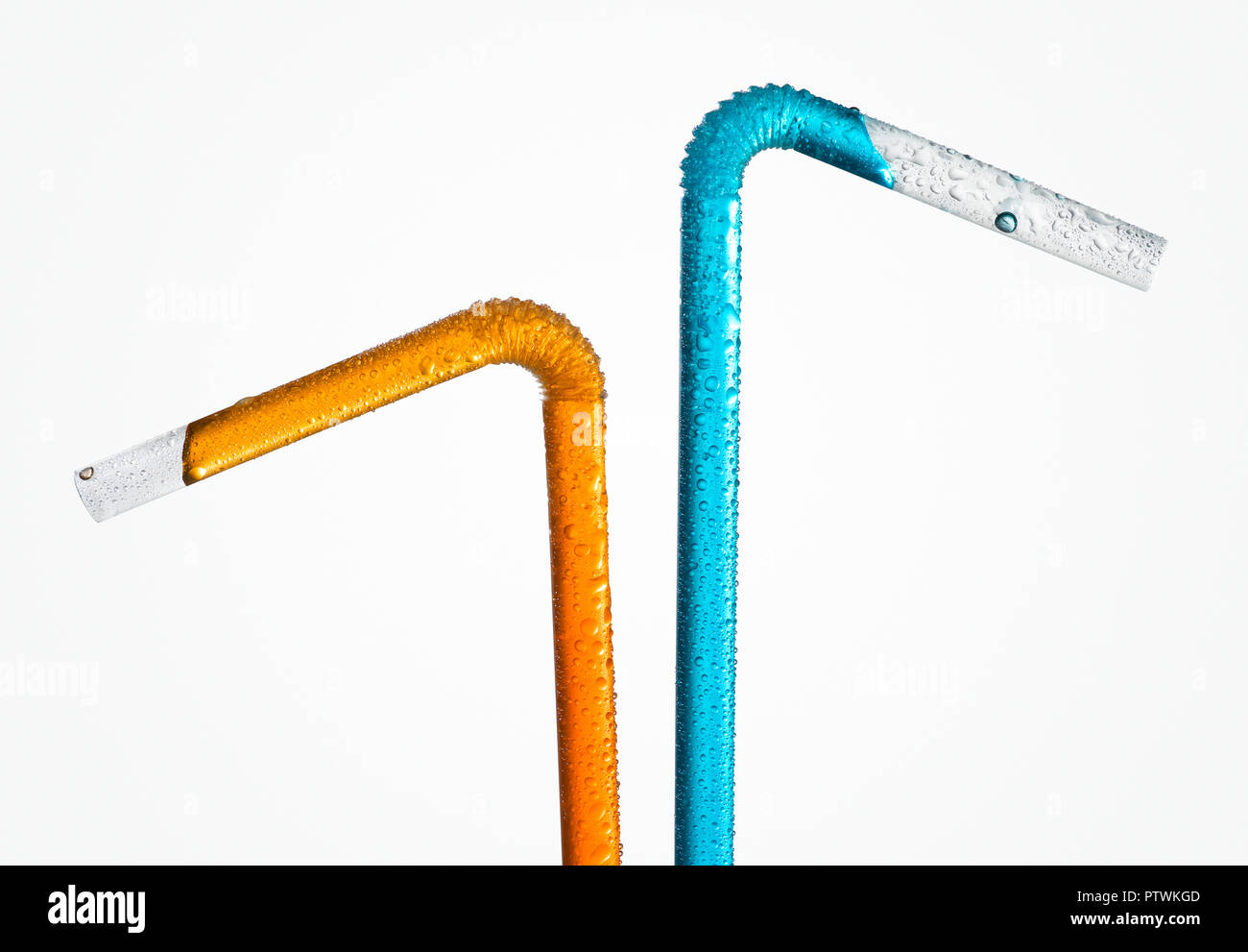 Two plastic drinking straws with orange and blue liquid, studio shot Stock Photo