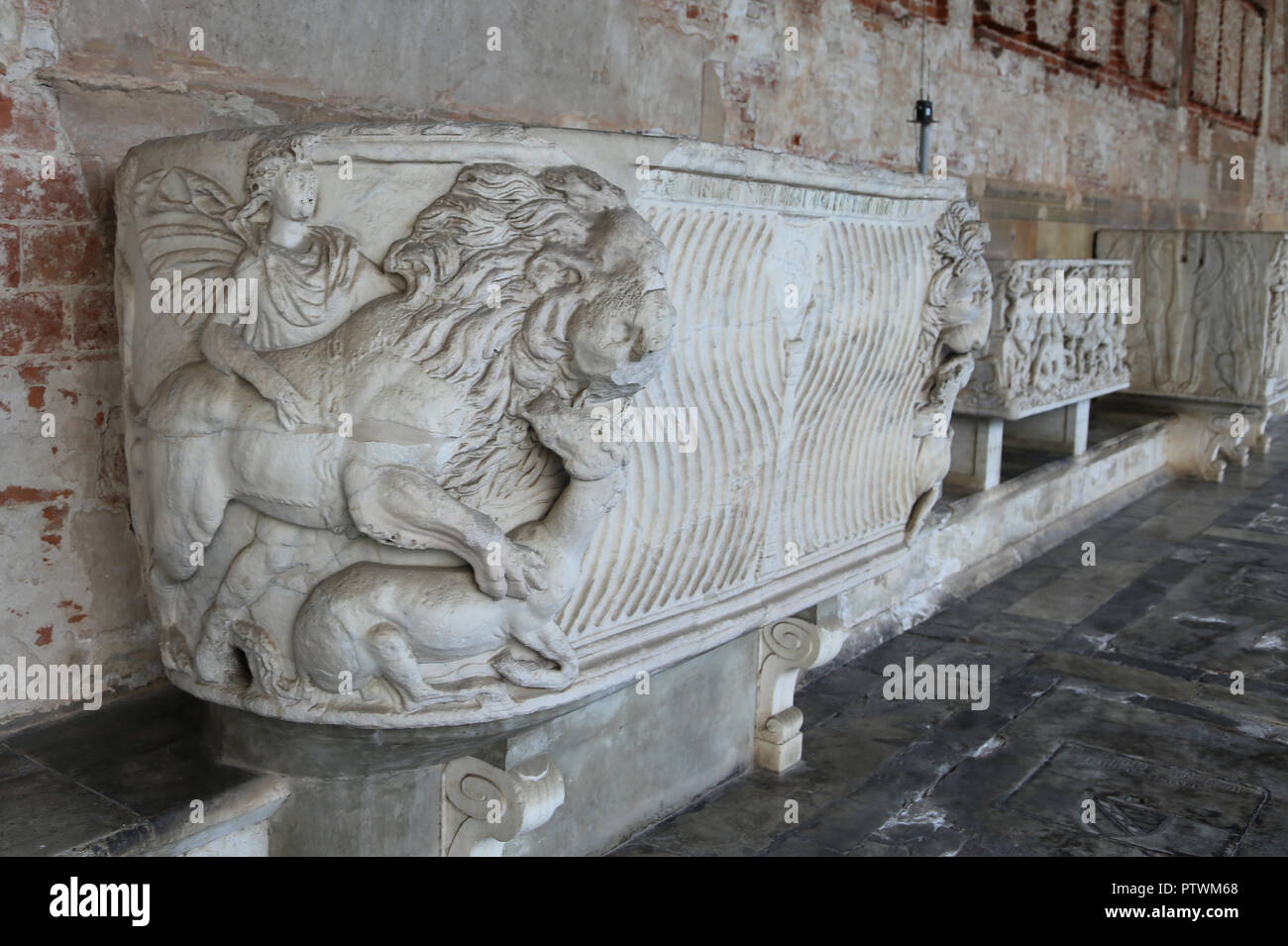Italy. Pisa. CampoSanto. Roman sarcophagus. Lion devouring a horse with male figure in a tunic and cloak and strigilatd ornament Stock Photo