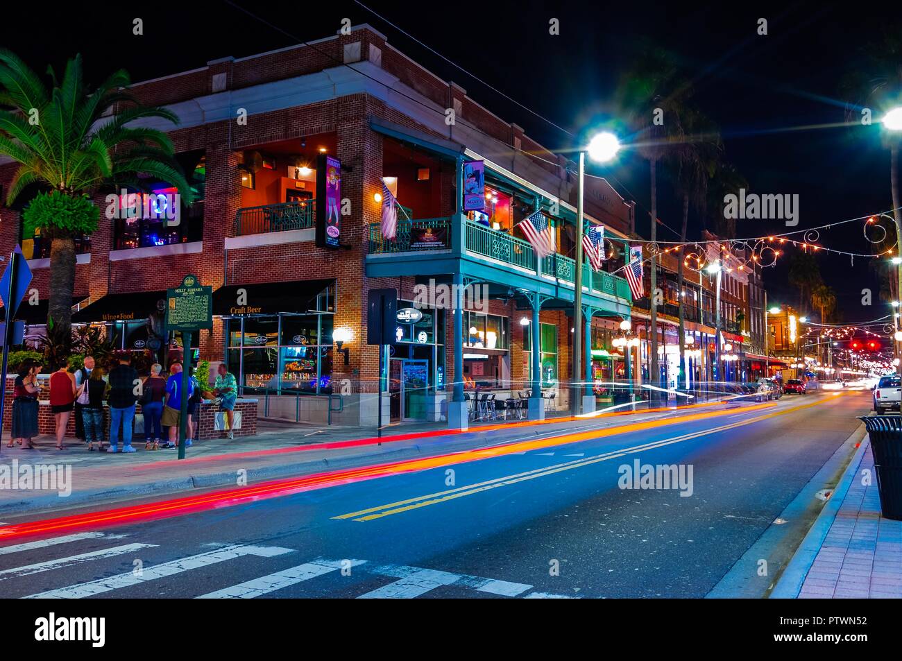 Tampa, FL—Oct 2, 2018; time exposure of cars traveling through Ybor city at night.  Ybor is a registered cigar manufacturing historic district. Stock Photo