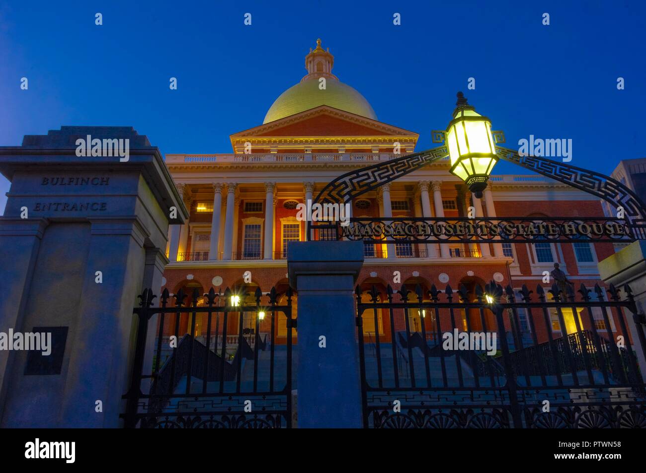 Time exposure of Massachusetts State House with golden dome and iron exterior fence at sunset in downtown Boston. Stock Photo