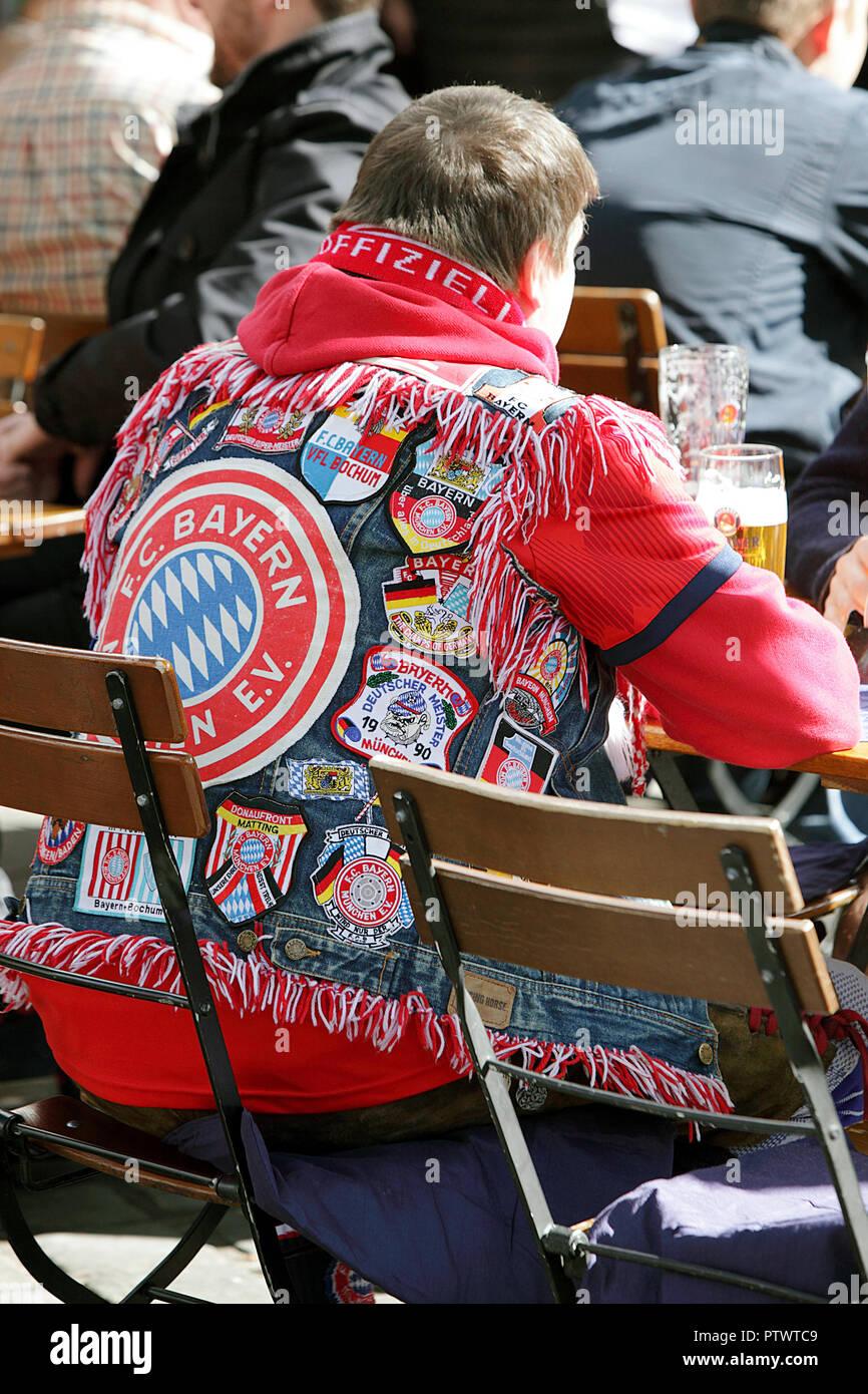 Bayern Munich football supporter quietly enjoying a beer in Munich centre market prior to the game. Stock Photo