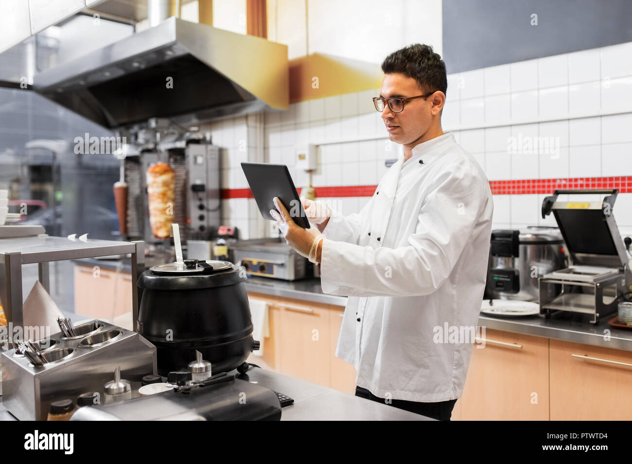chef cook with tablet pc at restaurant kitchen Stock Photo