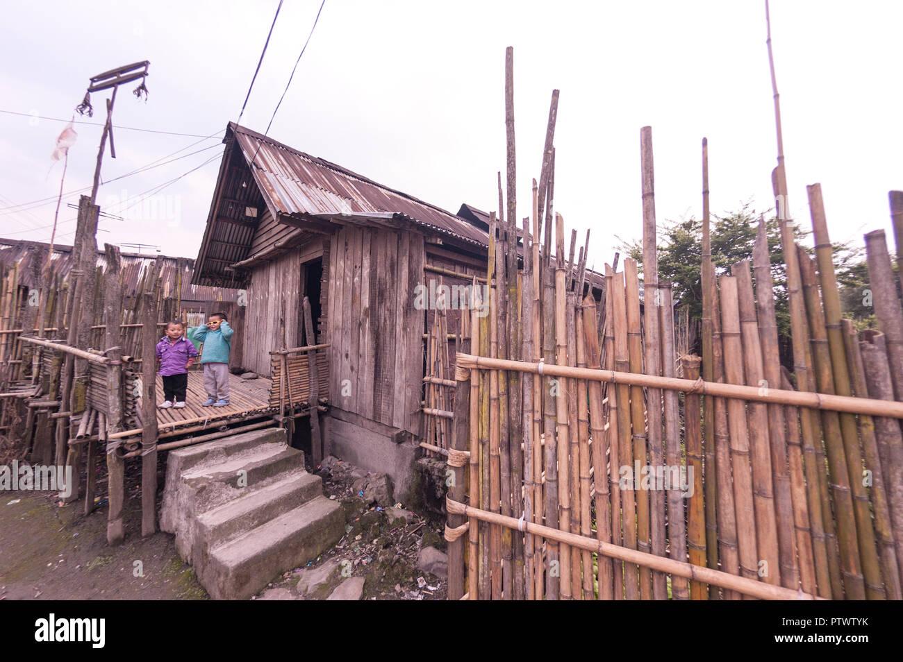 Apatani heritage hut,Child,modern dress,,bamboo, portico,fence.brick steps,Village,at Ziro,Arunachal  Pradesh,North East India. Stock Photo
