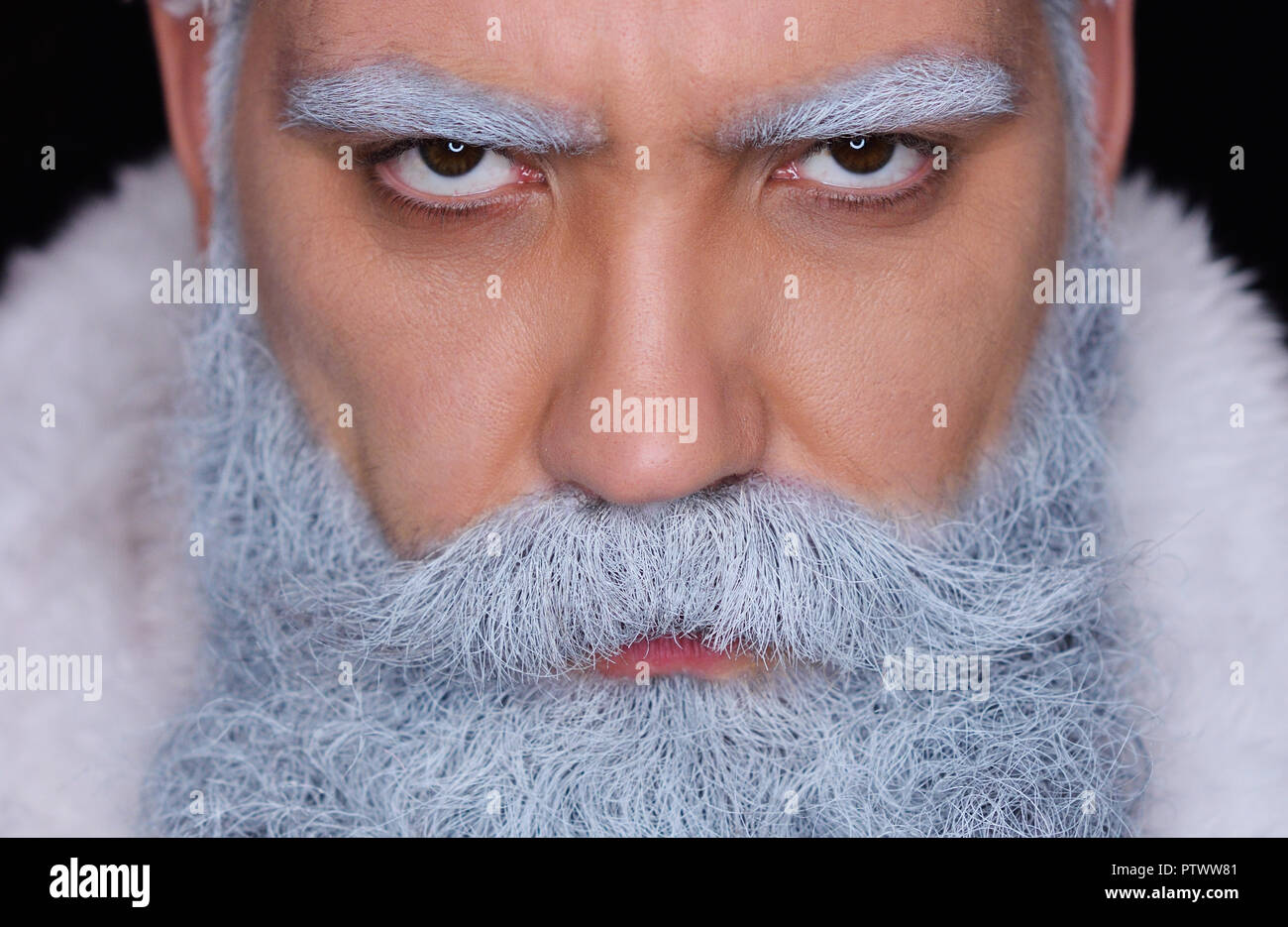 evil Santa Claus angrily looks at the camera on a dark background Stock