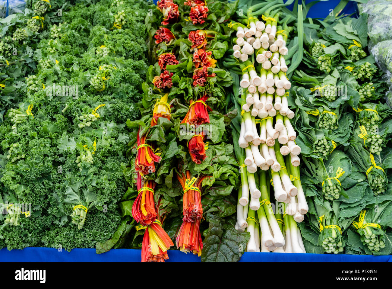 Fresh produce including leeks and swiss chard on display at the farmers market Stock Photo
