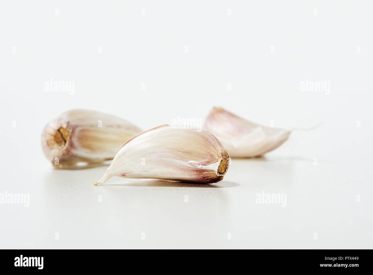 Three garlic cloves isolated on white in a studio Stock Photo - Alamy