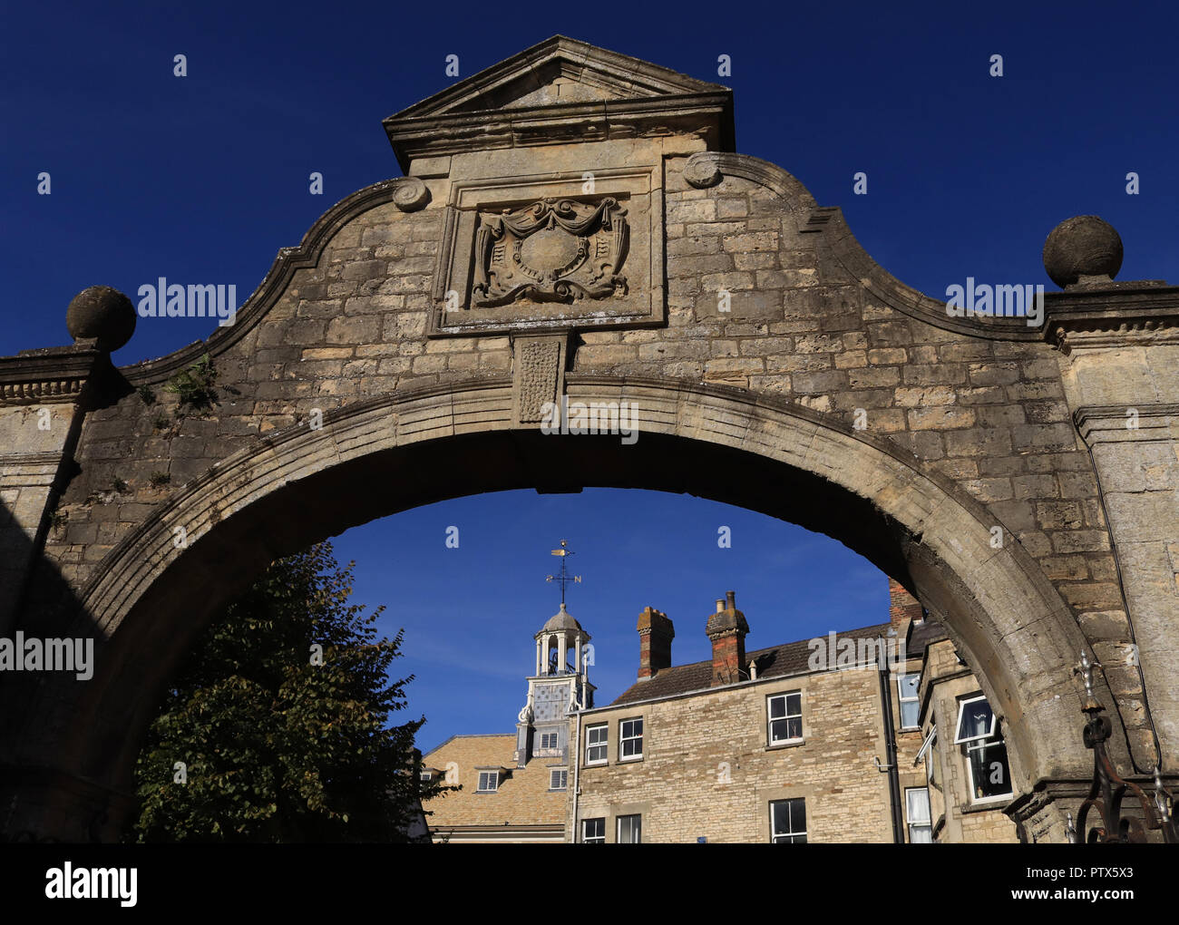 On a beautiful autumn morning the sun shines on the stone work of the court yard arch to the side of the Town hall in Brackley in Northamptonshire. Stock Photo