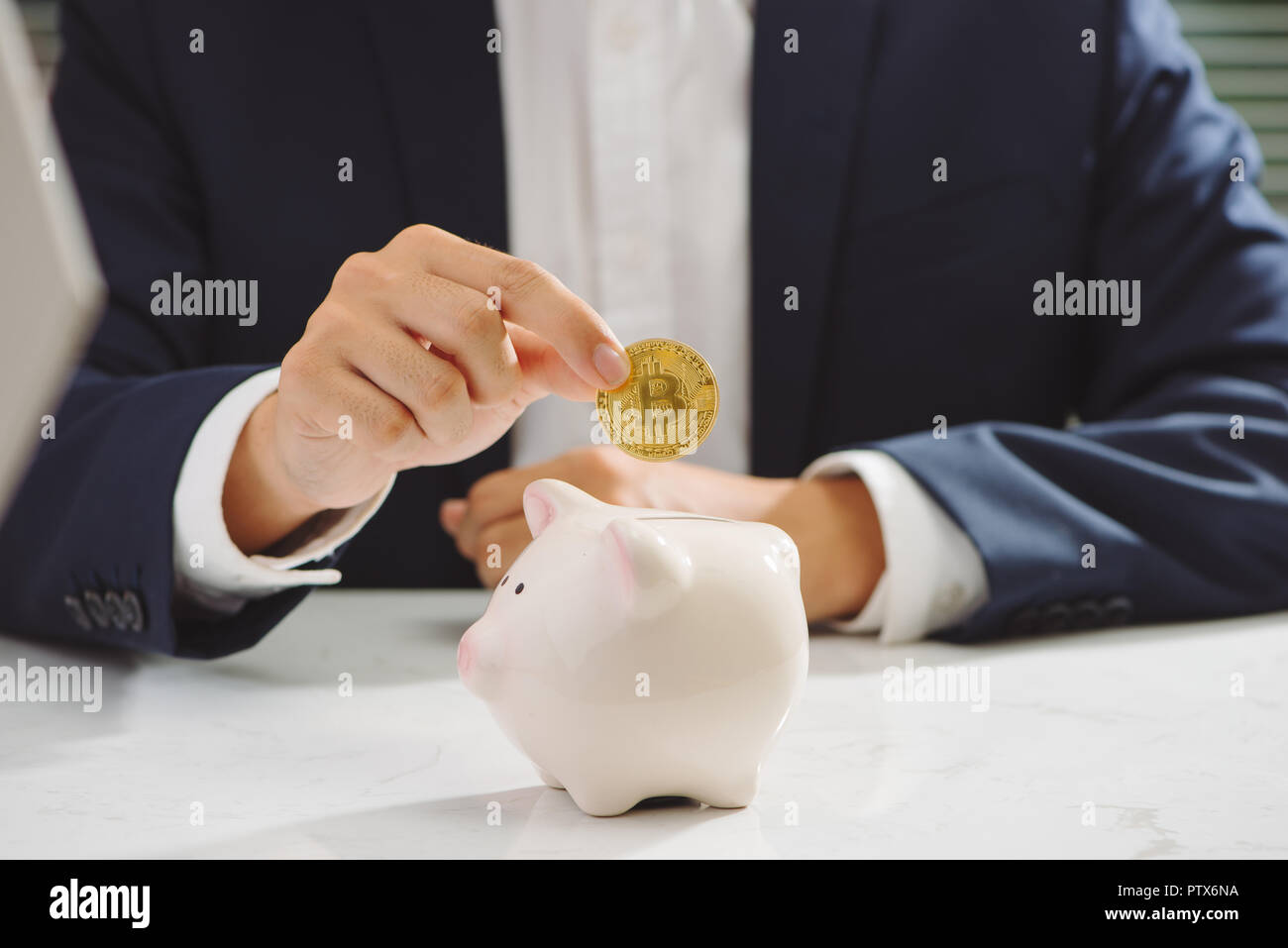 Businessman put bitcoin to piggy bank, bit coin BTC the new virtual electronic money, investment concept Stock Photo