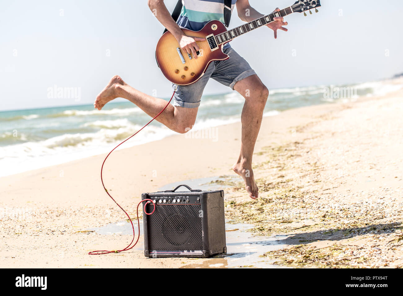 Beachy Instruments young stylish guy on the beach with musical instruments,the concept of ...