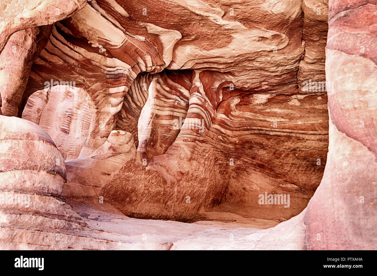 A view inside one of the burial chambers of Petra that shows the beautiful red rock striations of the sandstone in that part of Jordan. Stock Photo