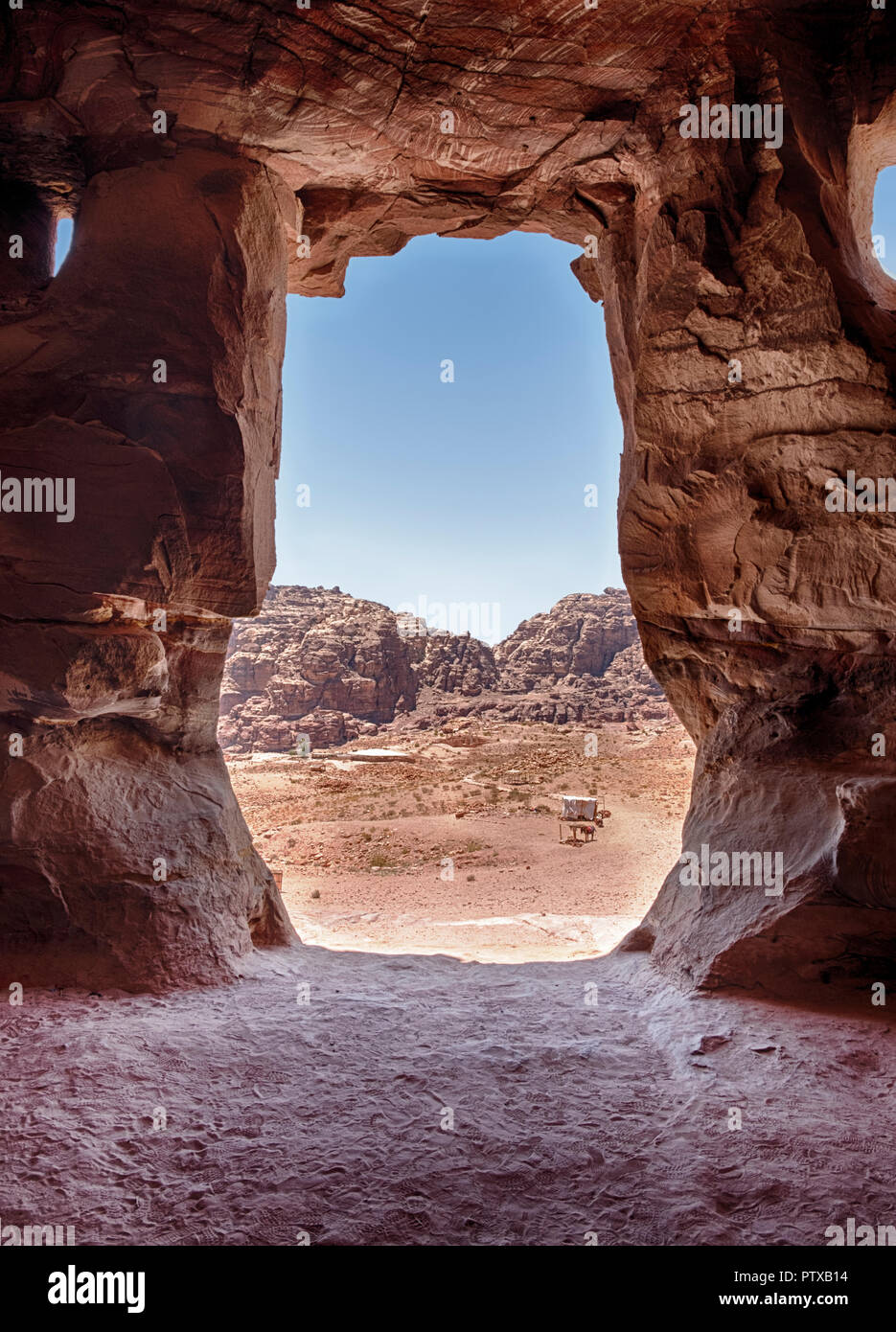 A view of the mountains of Petra through the stone entrance of one of the Royal Tombs. Stock Photo