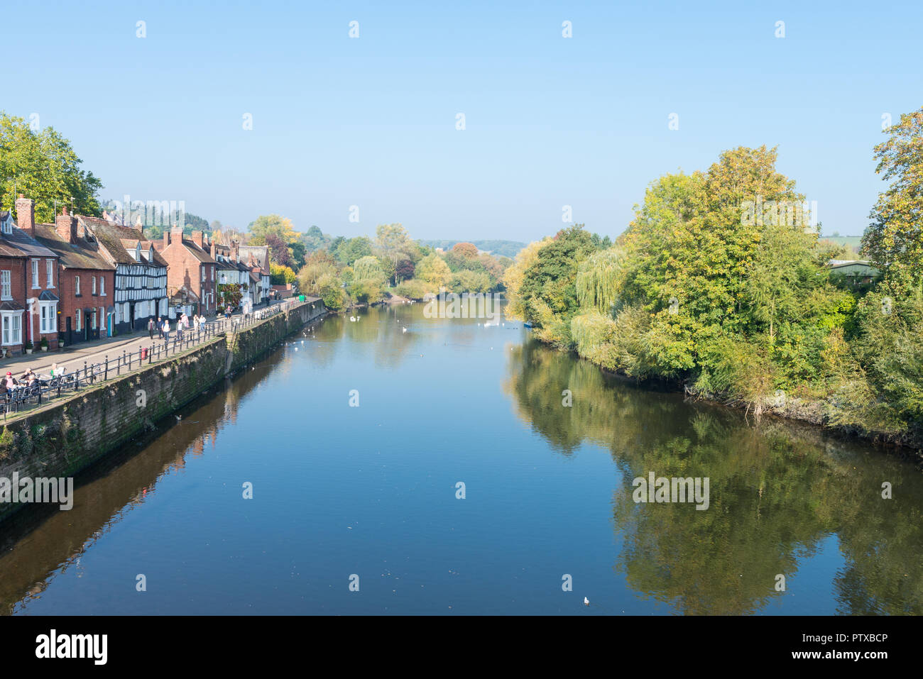 Pubs and cafes on the bank of the River Severn in Bewdley, Worcestershire with colourful treat on the opposite side Stock Photo