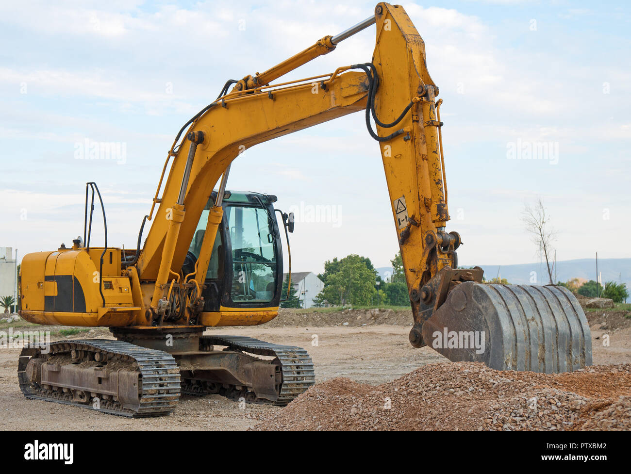 Yellow excavator working on the construction site Stock Photo - Alamy