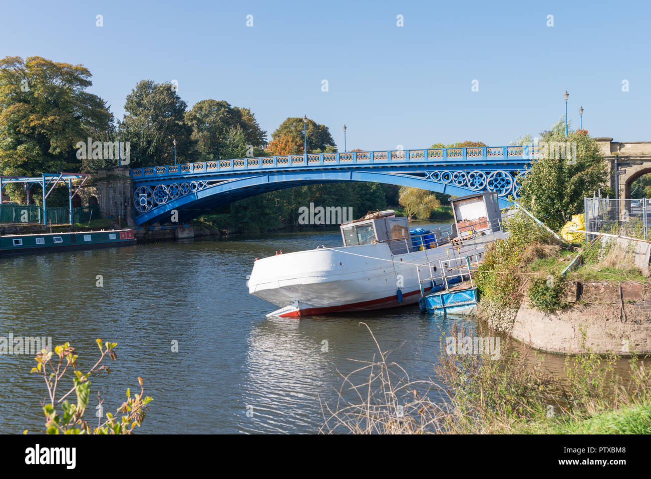 A large barge listing heavily whilst moored on the River Severn at