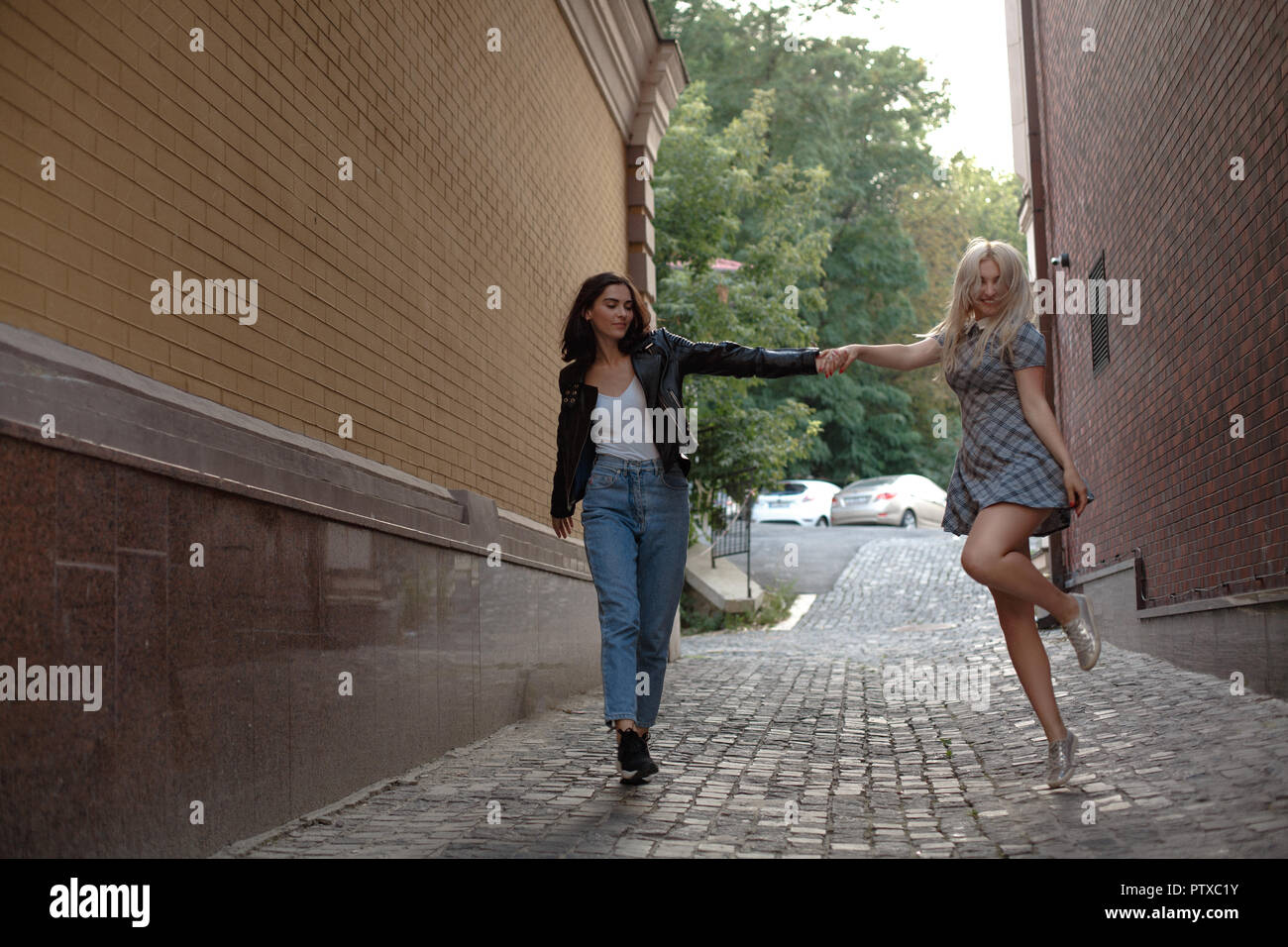 Two girls walking on the street Stock Photo - Alamy