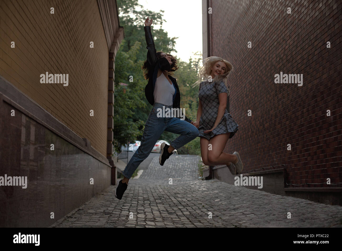 Two girls walking on the street Stock Photo - Alamy