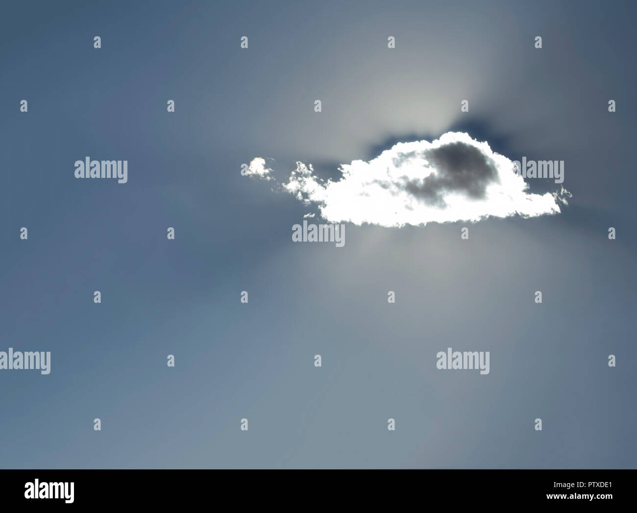 Sun Shining Behind a Single small cloud Stock Photo