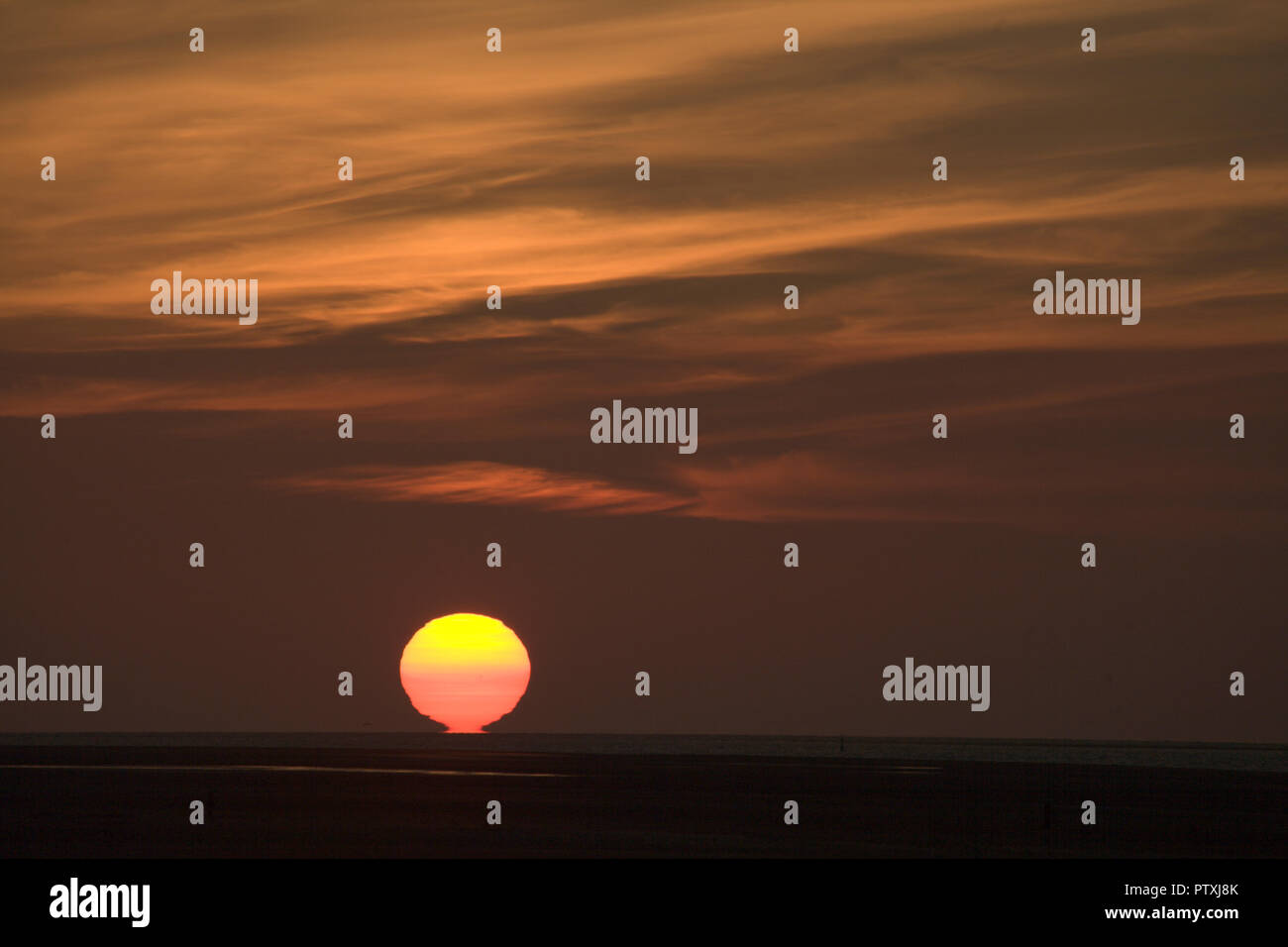 Sunset over the sea with colourful clouds Stock Photo
