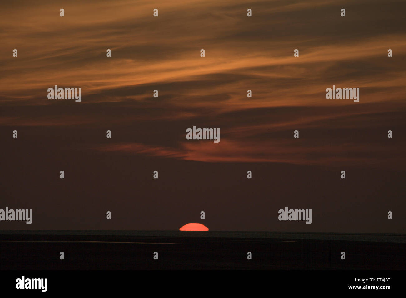 Sunset over the sea with colourful clouds Stock Photo