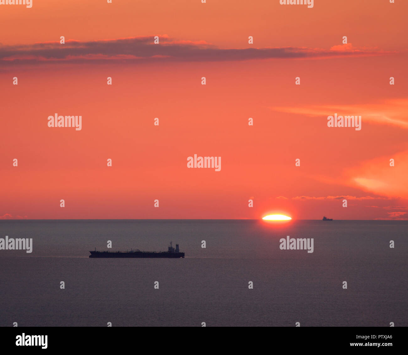 Ship on the sea at sunset with a colourful sky Stock Photo