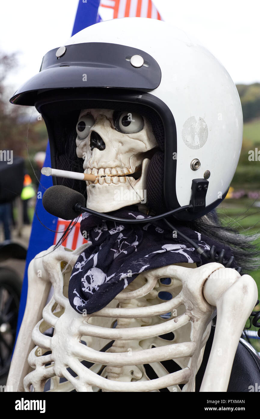 Skeleton in a helmet smoking a cigarette, sat on a Honda Motorcycle Stock Photo