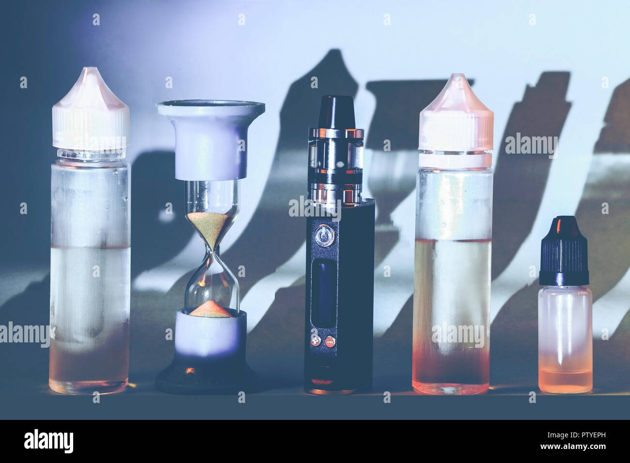 still life of vape, hourglass and e-cigarette refills, toned background  image Stock Photo - Alamy