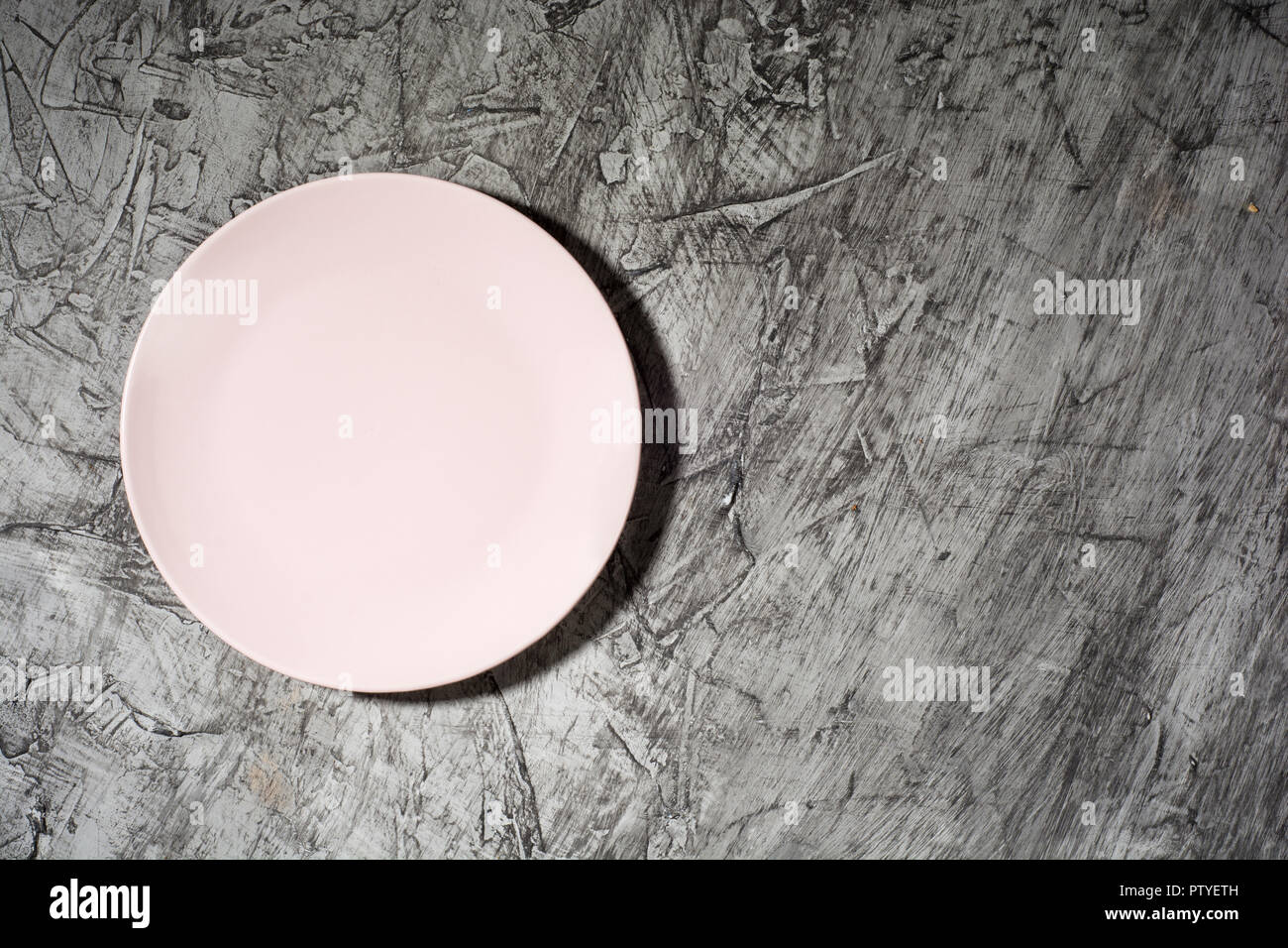Empty pink plate on concrete background with copy space. Flat lay.. Stock Photo