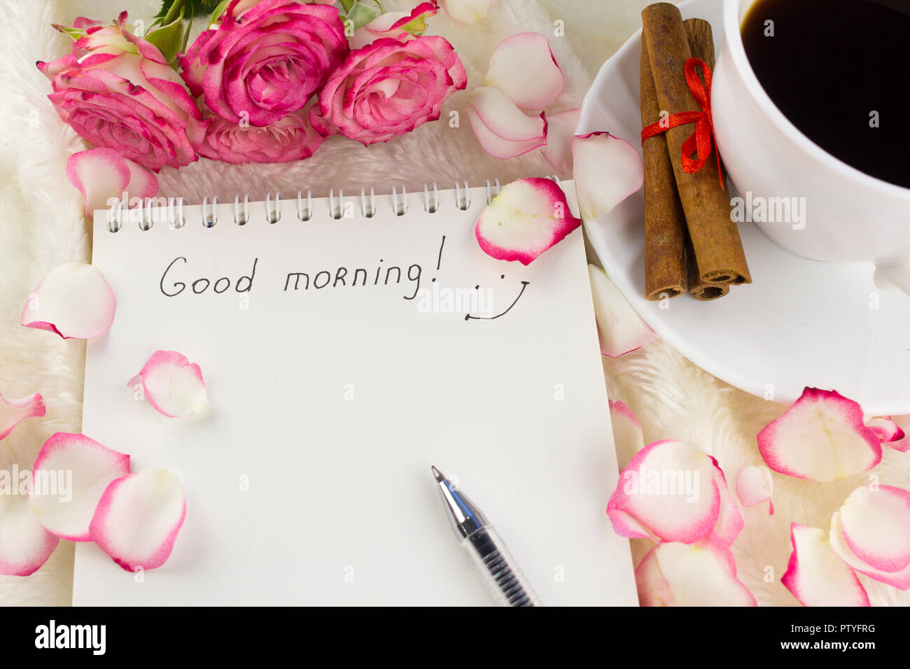 A clean notepad with the inscription good morning, rose petals ...