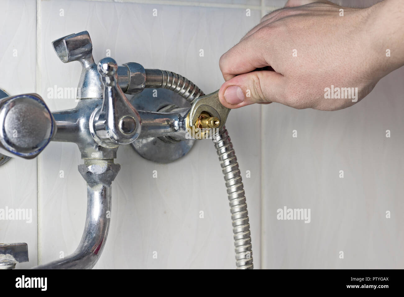A man is repairing a water tap, a close-up Stock Photo
