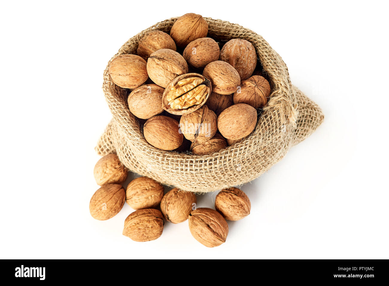Whole walnuts (in shell) in burlap sack isolated on white background