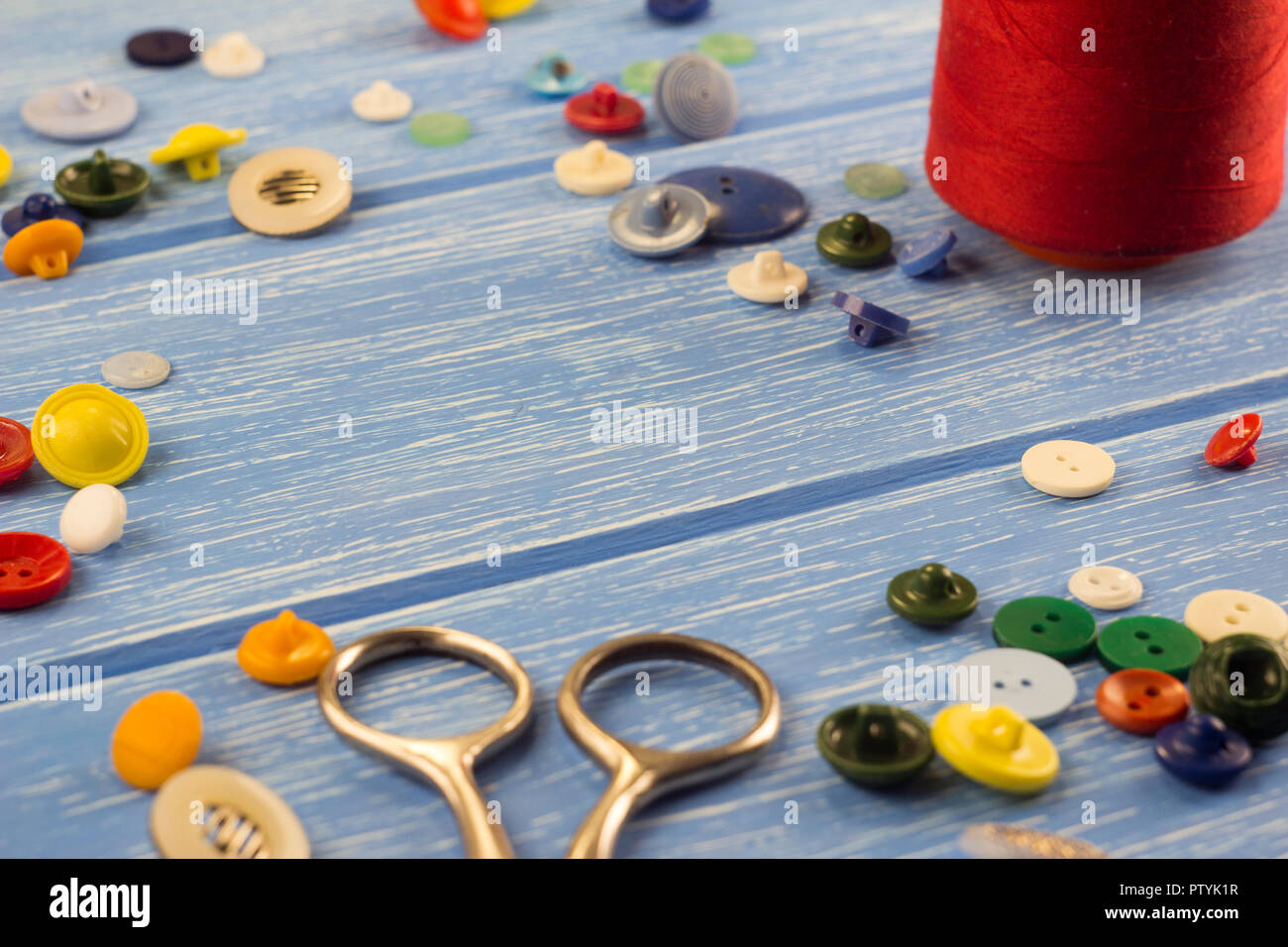scissors, buttons and threads on a wooden background Stock Photo